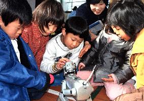 Elementary school pupils touch AIBO robot dog